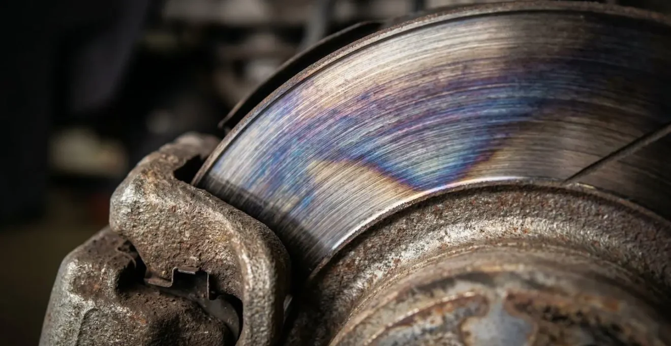 Gros plan macro sur un étrier de frein montrant les signes de surchauffe avec coloration bleue du disque