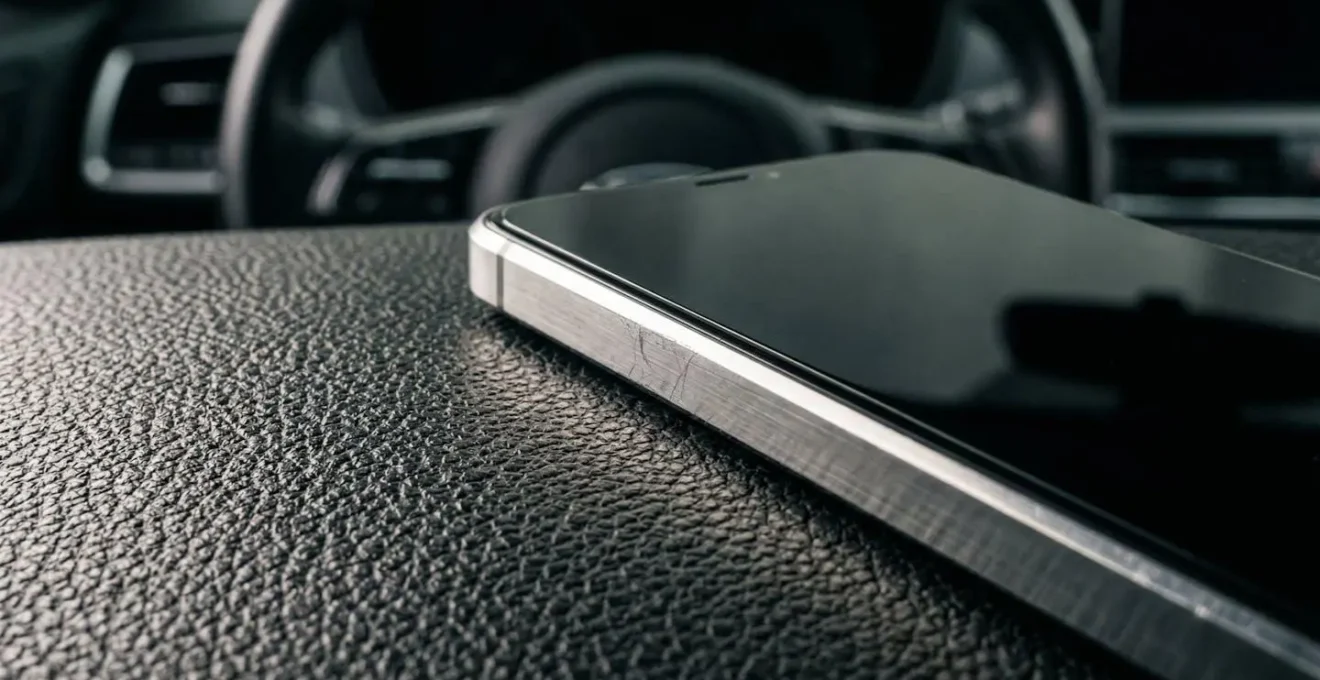 Gros plan sur un tableau de bord de voiture avec un smartphone posé, sans texte visible